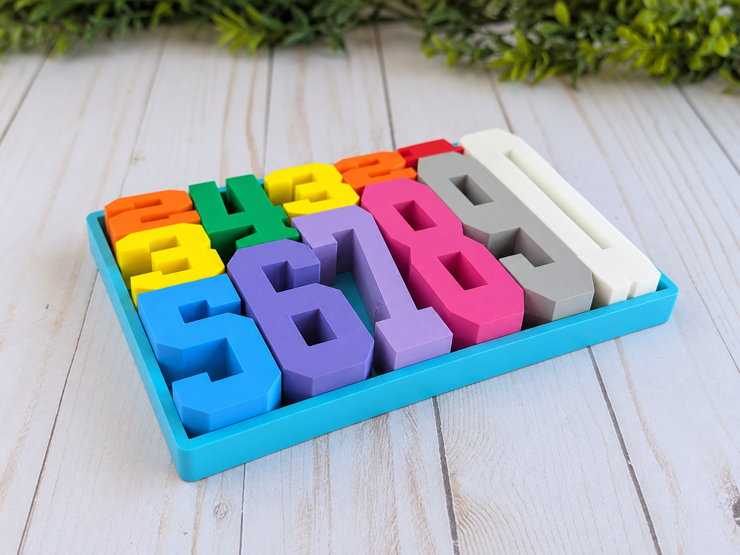 Farbenfrohes Zahlen-Puzzle von 1 bis 10 ordentlich im Aufbewahrungstablett angeordnet.